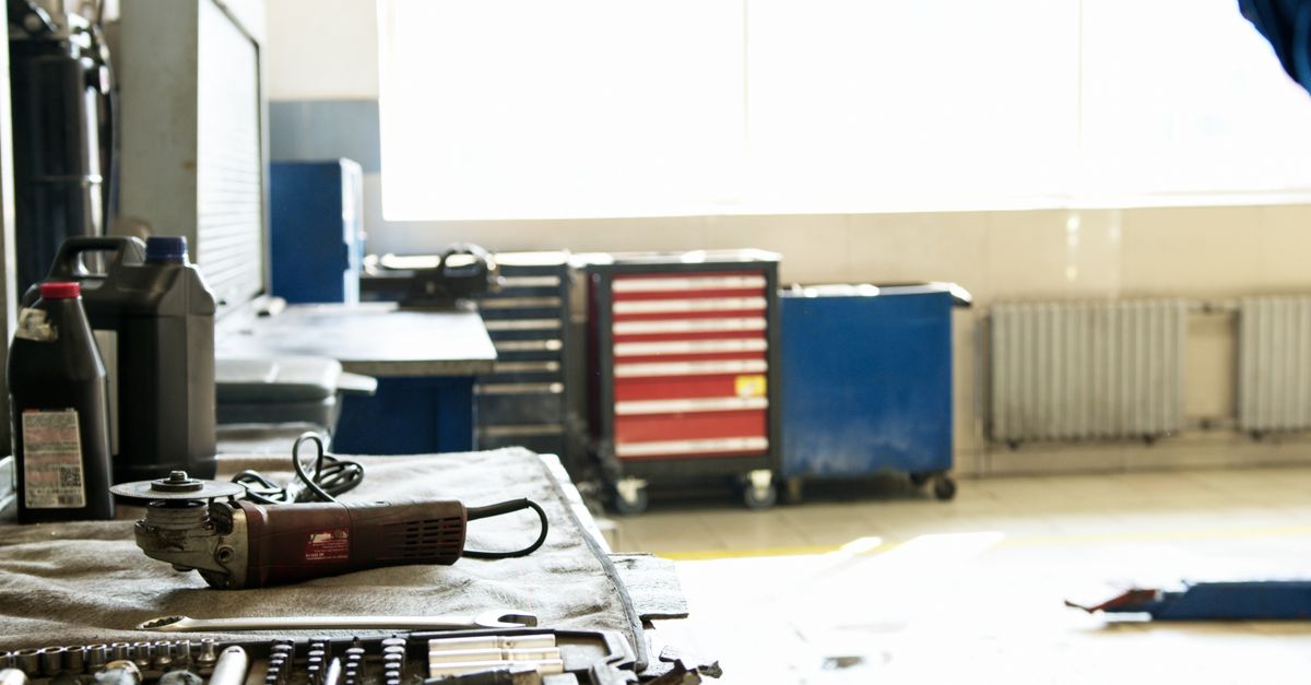A well-organized industrial workshop showing tools, an angle grinder, and storage cabinets.
