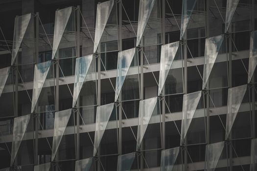 A striking modern building facade showcasing glass panels and geometric patterns, offering a sleek architectural style.