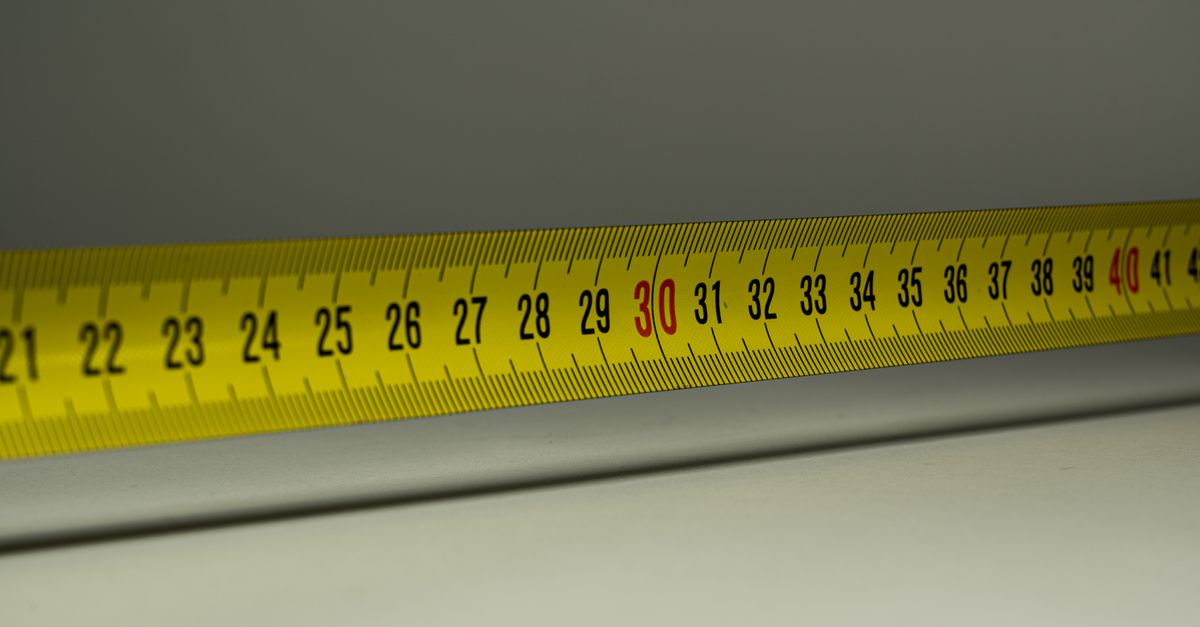 Close-up view of a yellow measuring tape with centimeter marks, emphasizing precision in measurement.