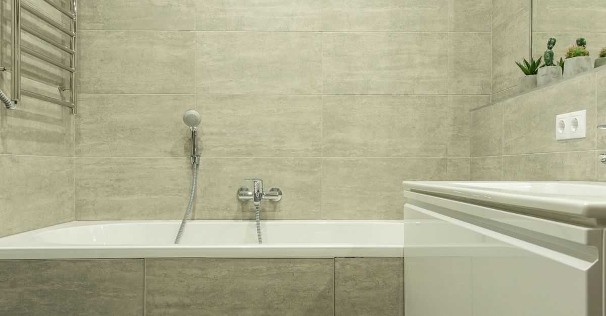 A clean and modern bathroom interior showcasing a ceramic bathtub and stylish tiles.