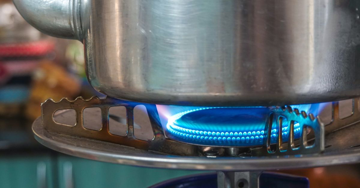 A detailed image showing a gas stove burner with a pot above, highlighting kitchen heat and flame.