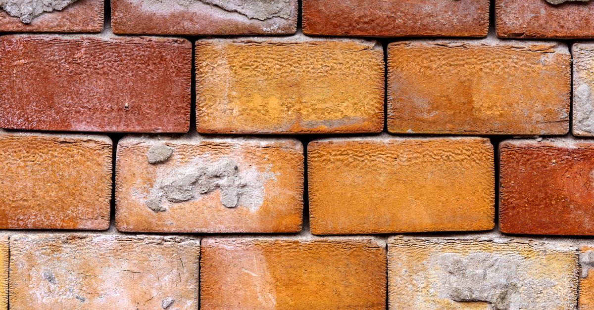 Detailed close-up of an aged brick wall, showcasing texture and construction pattern.