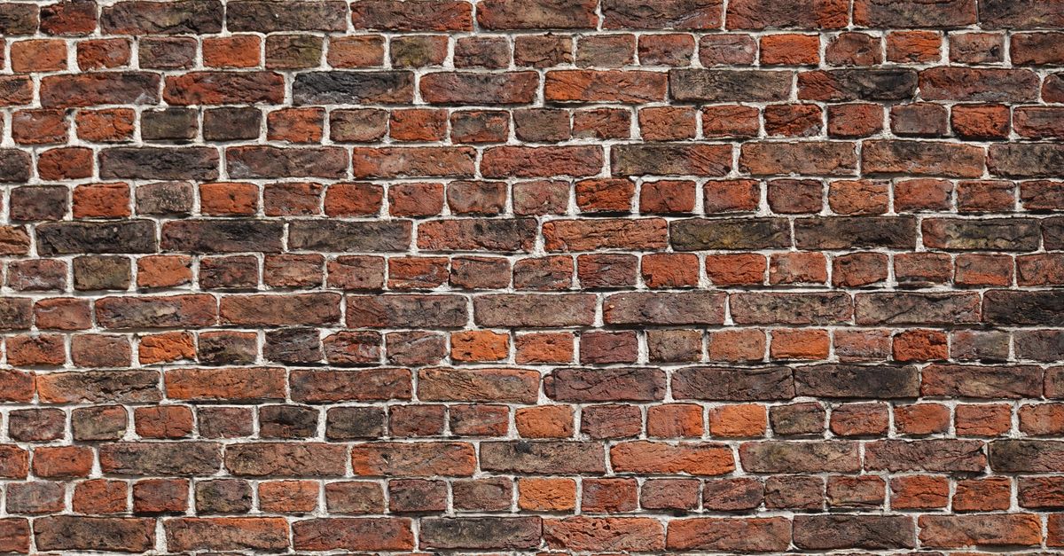 Close-up of a red brick wall displaying rustic texture and pattern, ideal for background use.