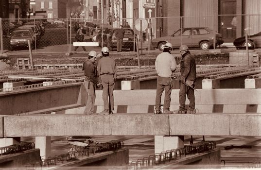 Group of construction workers discussing plans on an urban construction site.
