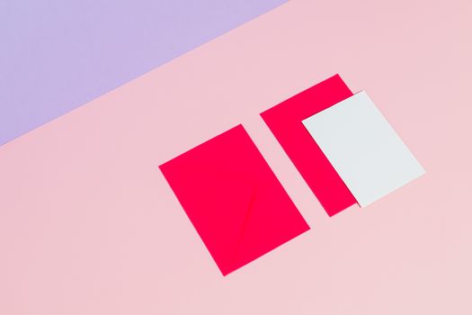 Bright red envelopes with white cards on a pastel pink and purple backdrop, ideal for mockups.