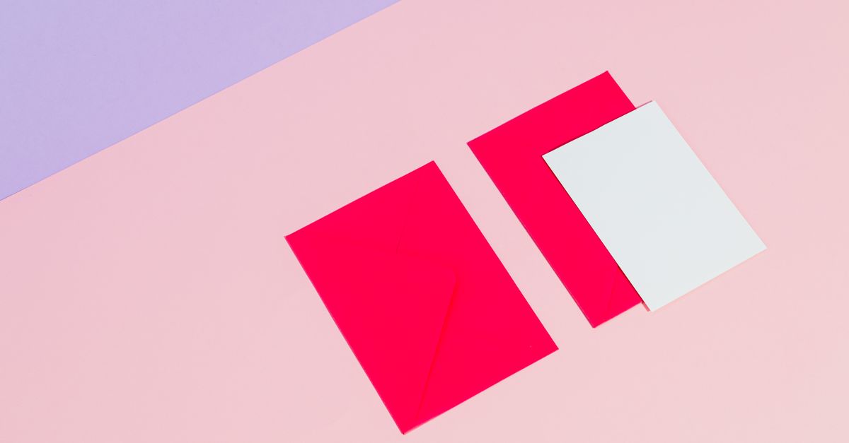 Bright red envelopes with white cards on a pastel pink and purple backdrop, ideal for mockups.