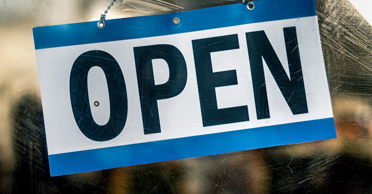A blue and white open sign hanging on a retail shop's glass door.