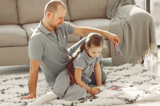 Father and daughter coloring together on the living room floor, enjoying quality time.