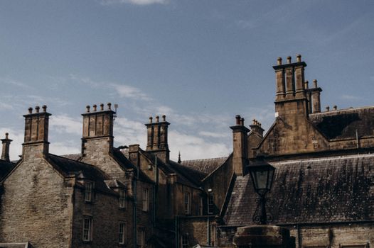 A captivating view of historic Gothic brick buildings with tall chimneys under a clear sky.