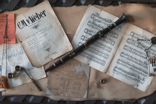 A flat lay of a vintage clarinet with sheet music and antique items, evoking a classic musical vibe.