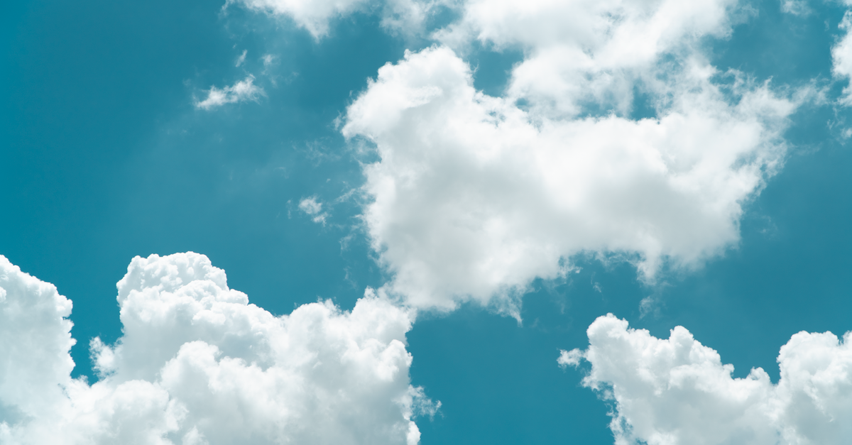 A vibrant blue sky filled with fluffy white clouds on a sunny day.