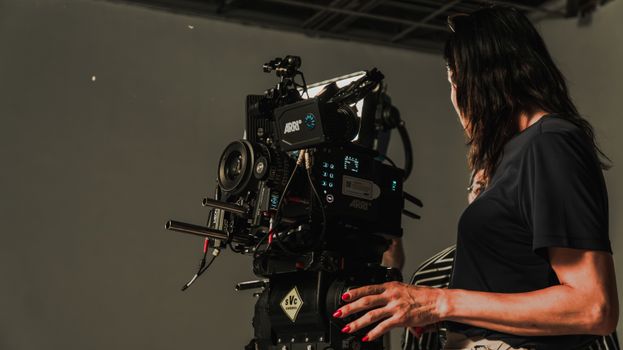Close-up of a film crew operating a camera rig in a studio, capturing a cinematic production.