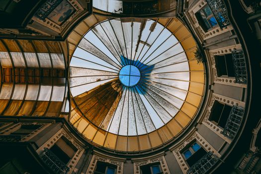 Intricate glass dome ceiling in a historic building interior, capturing geometric patterns and natural light.