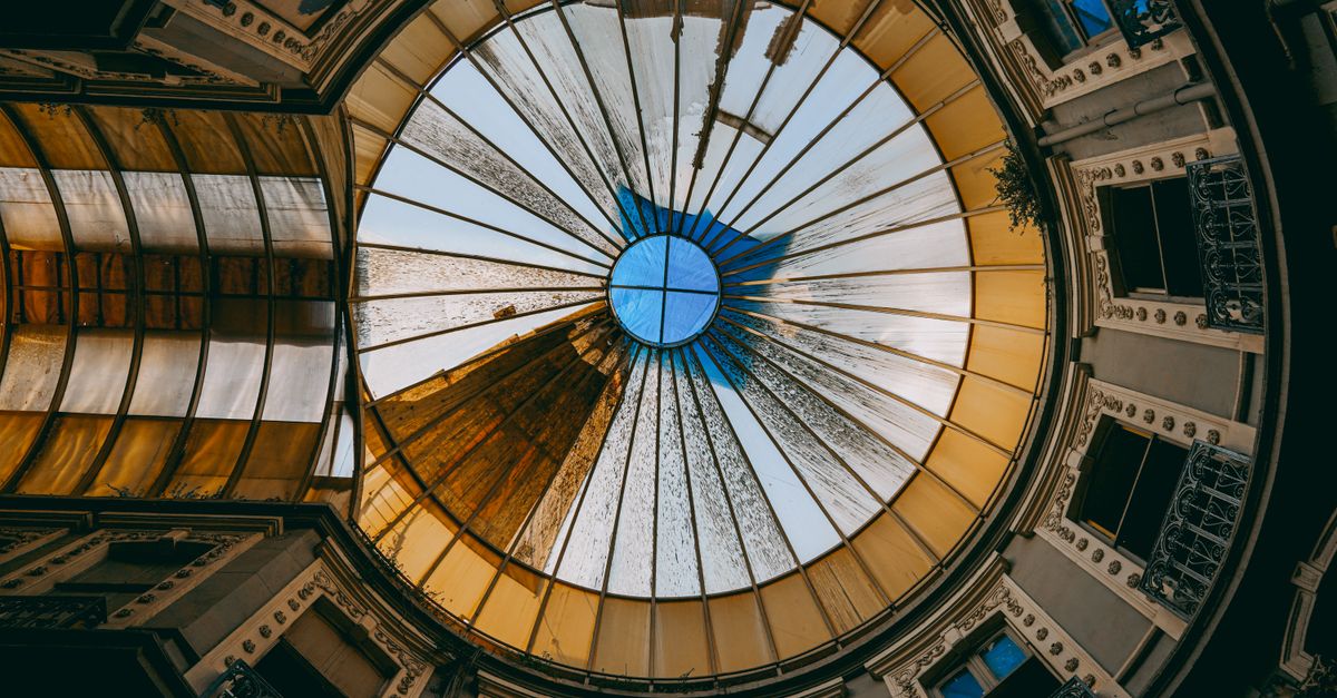 Intricate glass dome ceiling in a historic building interior, capturing geometric patterns and natural light.