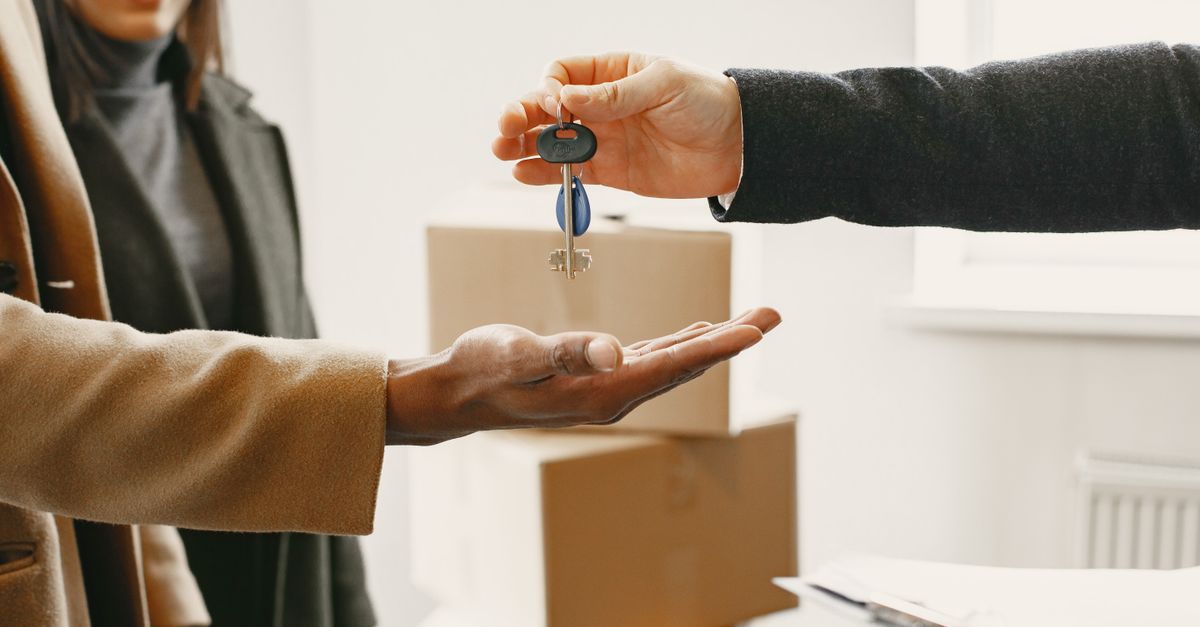 A new homeowner receives keys inside their new home, symbolizing a fresh start.