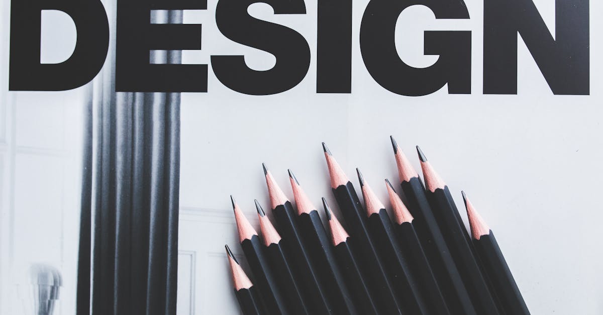 Black pencils arranged creatively next to large typography 'DESIGN'.