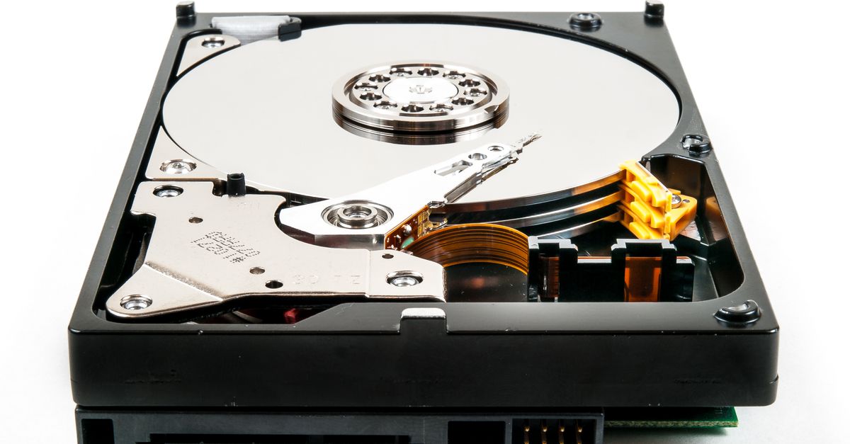 Detailed view of an open hard drive showcasing internal components against a white backdrop.