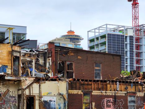 An urban demolition site with a mix of old and modern architecture in the background.