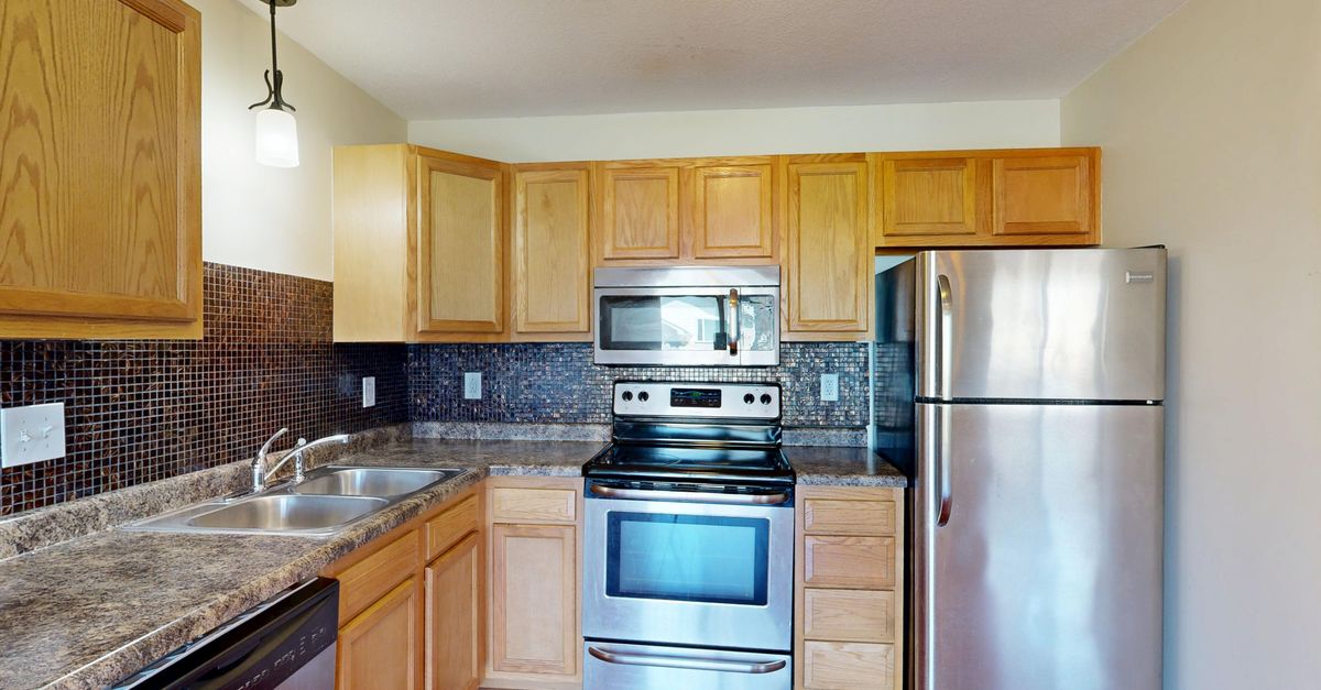 Contemporary kitchen featuring stainless steel appliances and wooden cabinetry.