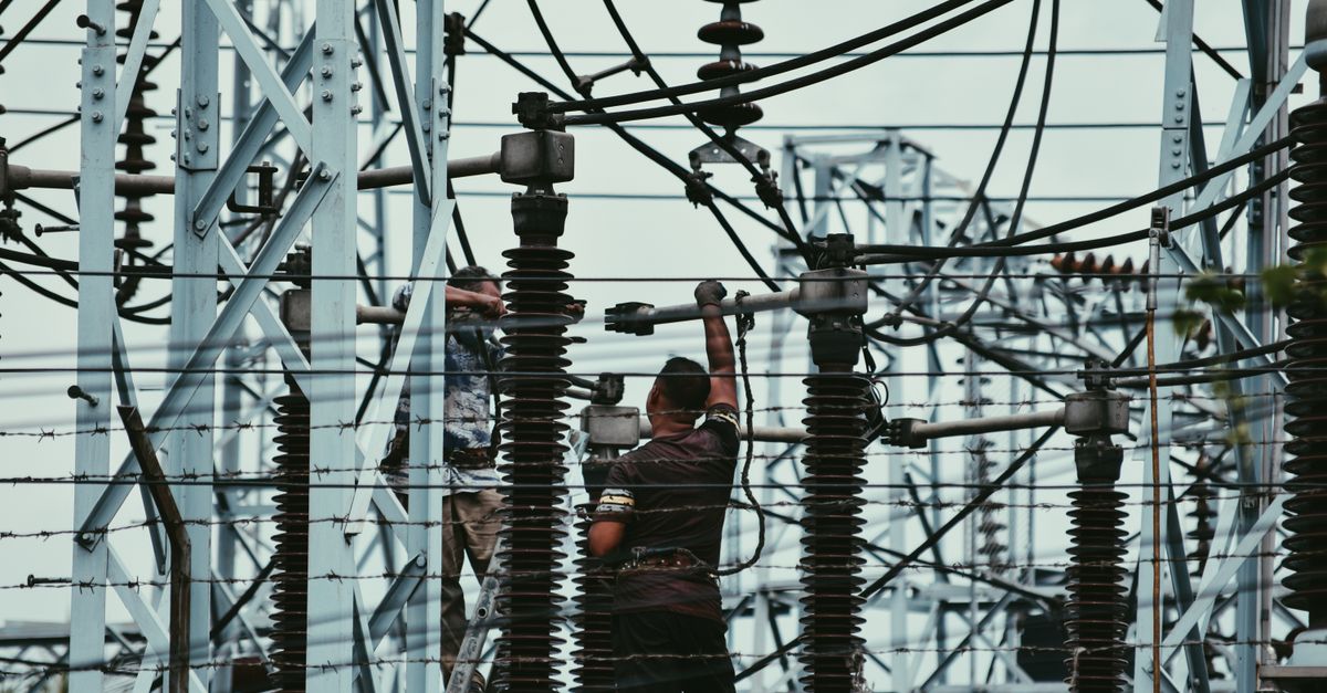 Electricians working on power lines, ensuring grid maintenance and safety.