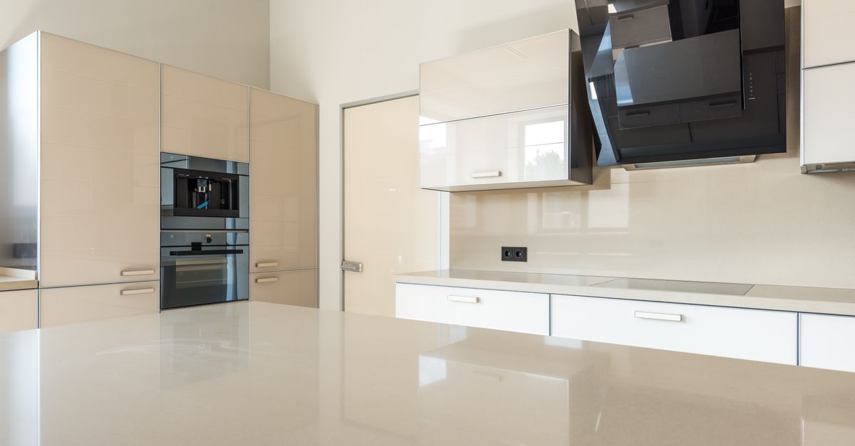 Sleek and spacious modern kitchen design featuring glossy cabinets and high-end appliances.