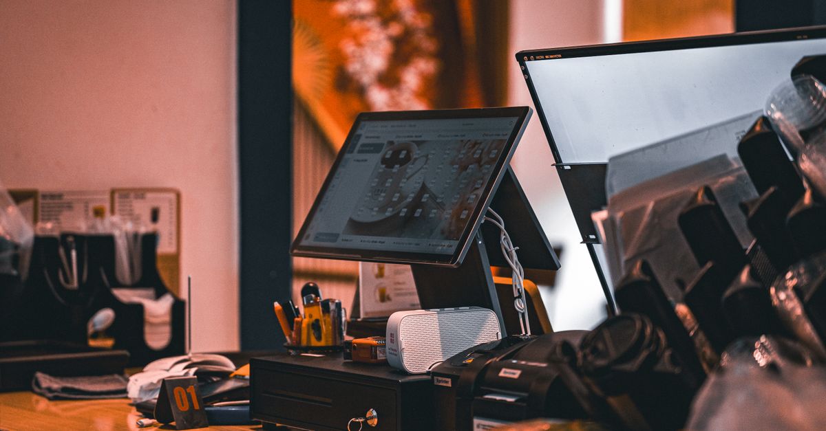 Counter with cash register and computer screen in Ho Chi Minh City cafe, offering a modern and warm ambiance.