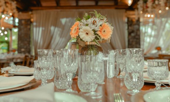 Crystal glassware and floral centerpiece adorn an elegant dining setup, creating a warm and festive ambiance.