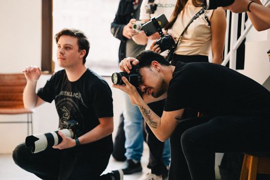 Photographers collaborating during an indoor event, capturing professional images.