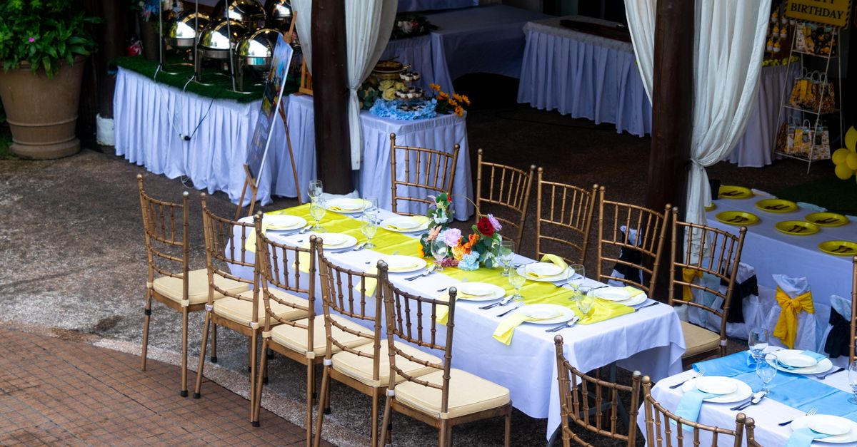 A beautifully arranged outdoor dining setting for a birthday party with vibrant decor and table arrangements.