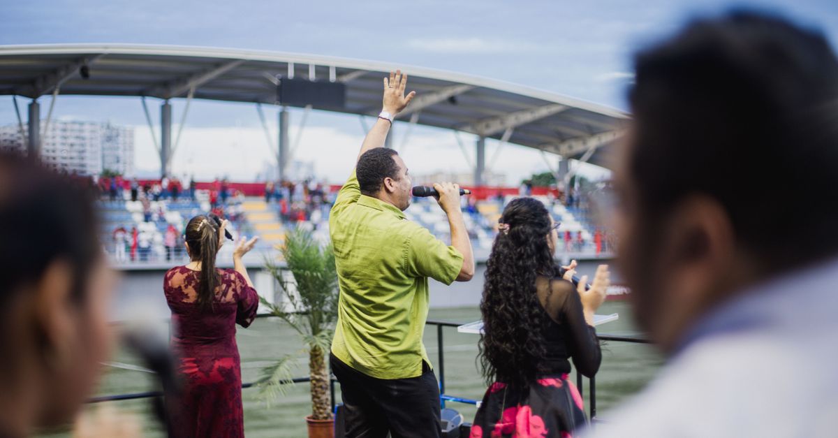 Energetic live music performance at an outdoor stadium with a diverse group of performers.