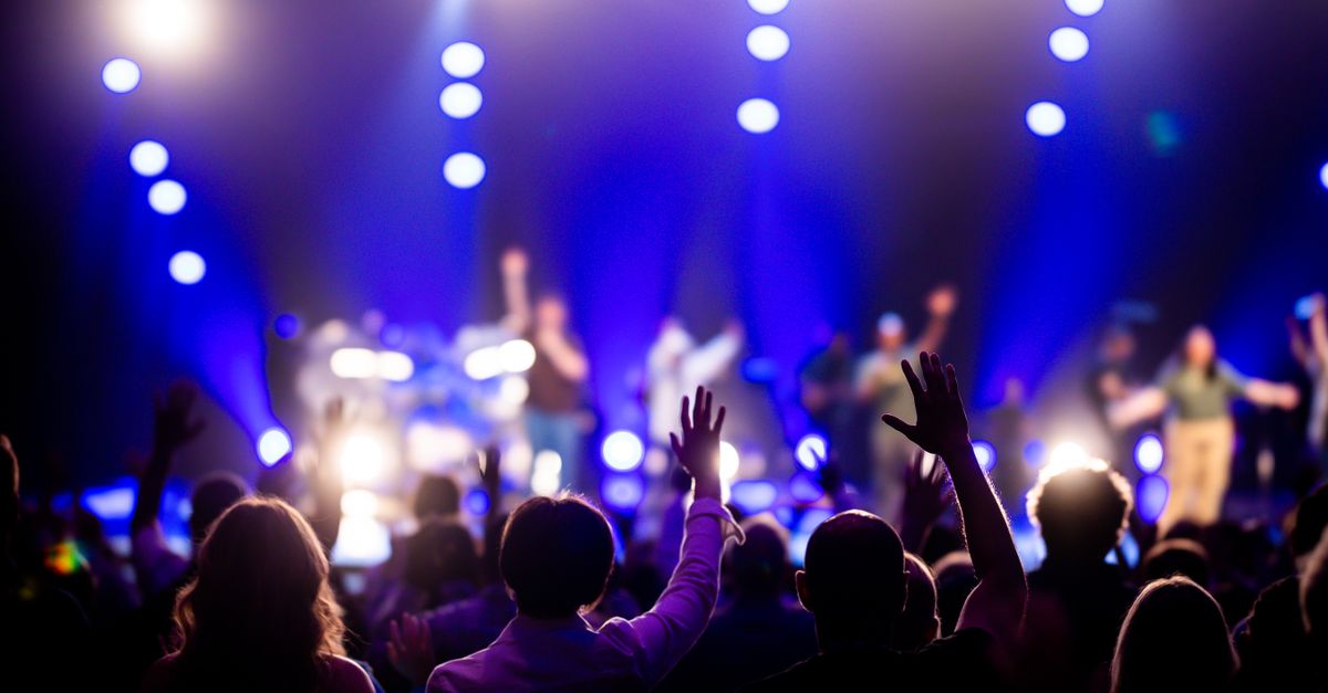 A vibrant concert scene with an engaged audience enjoying live music under dramatic lighting.