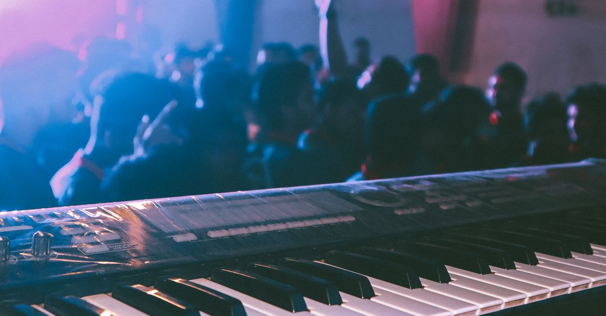 Dynamic concert environment with audience and electronic keyboard in focus, capturing lively music vibes.