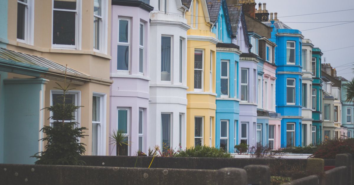Vibrant row of Victorian-style houses with colorful facades in a residential neighborhood.
