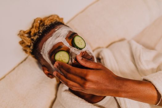 A person enjoying a calming spa experience with cucumber slices on their eyes.
