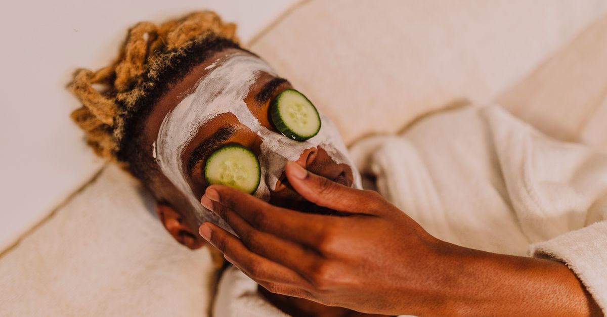 A person enjoying a calming spa experience with cucumber slices on their eyes.