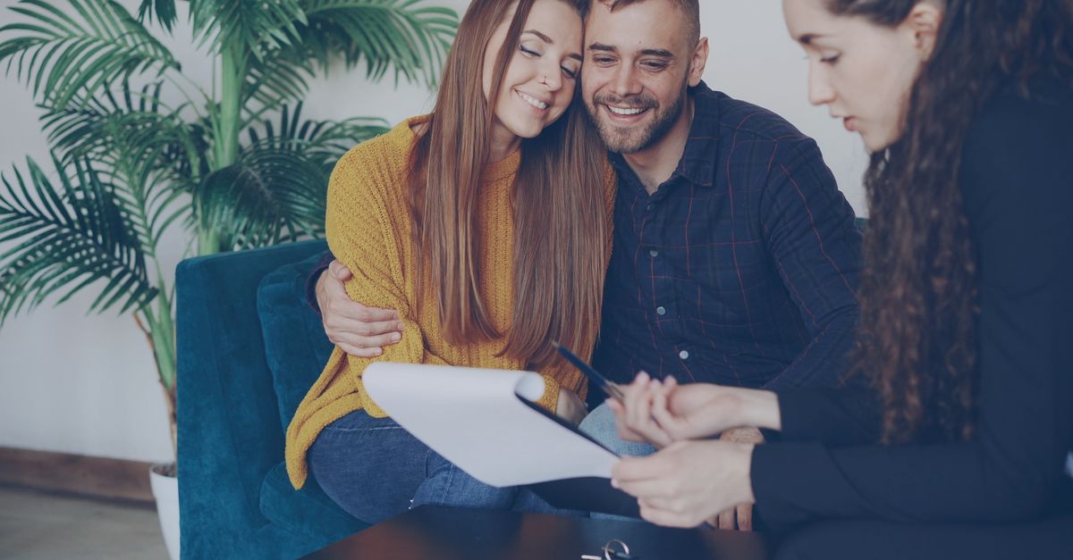 Smiling couple consulting with an adviser in a cozy office setting.