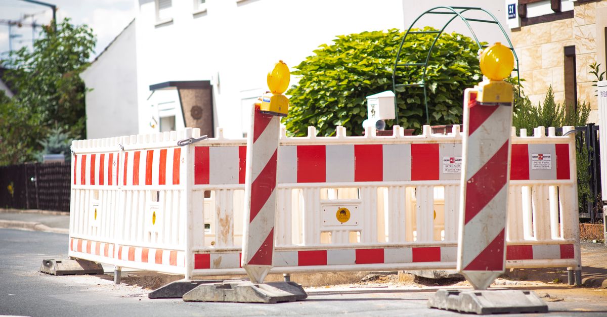 Bright road barrier with striped pattern signals construction on suburban street.