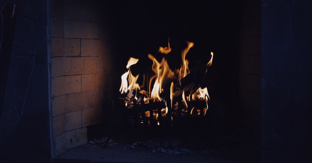A close-up of a warm, inviting fireplace with flickering flames, perfect for a cozy interior setting.