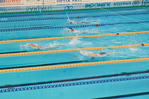 Action-packed swimming competition in Jakarta pool. Swimmers racing in lanes.