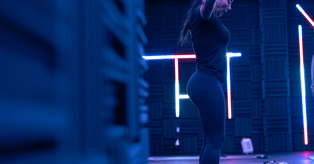 Fitness enthusiast exercising in a stylish neon-lit studio, embodying strength and focus.