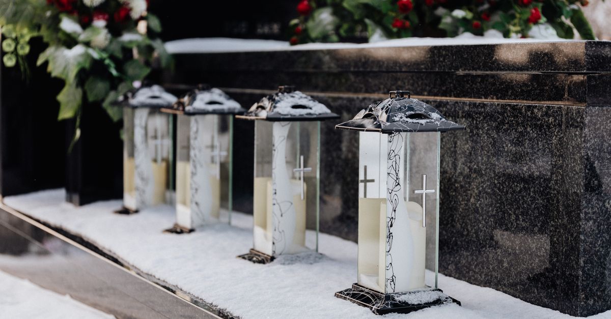 Cemetery lanterns in snow, creating a serene winter memorial scene.
