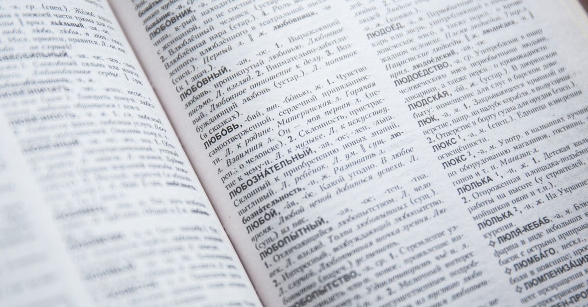 Close-up view of an open Russian dictionary showing detailed text and entries.