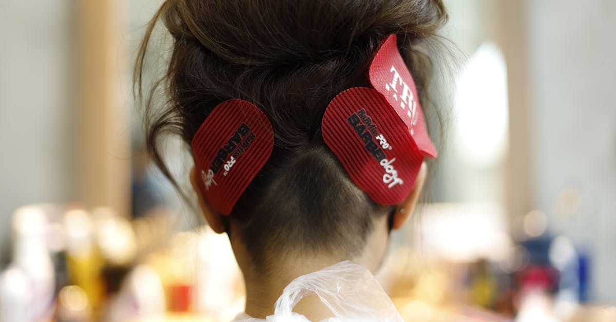 Back view of woman with brown hair and clips in salon setting.