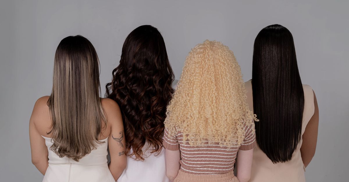 Four women showing diverse hairstyles from behind, emphasizing hair texture and color.