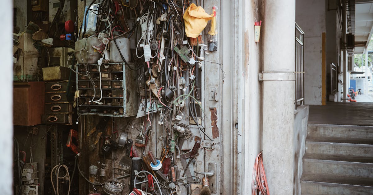 Wires, tools, and gadgets clutter the wall of a mechanic's workshop showcasing an industrial vibe.