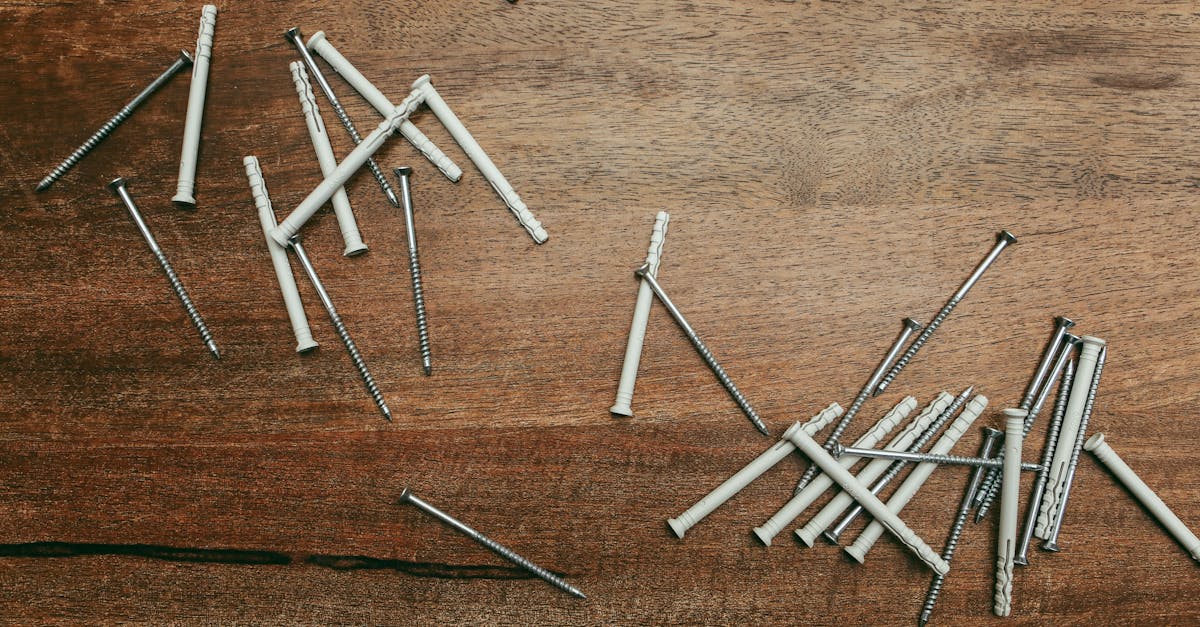 Close-up of nylon anchors and screws scattered on a wooden surface, perfect for DIY projects.