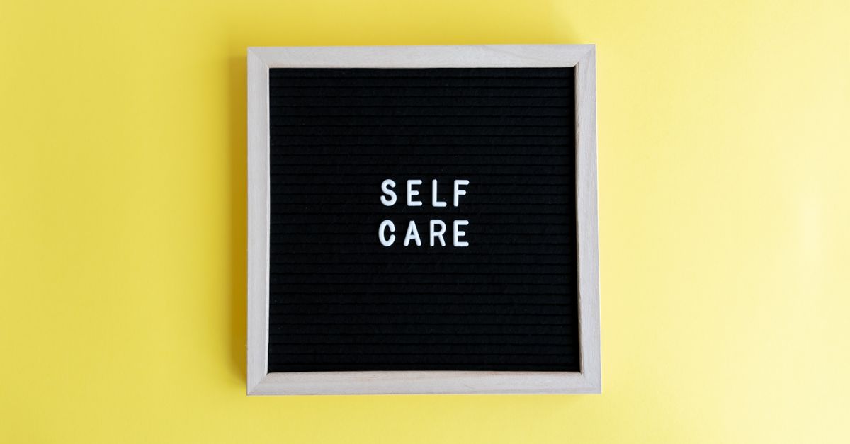 Inspiring self care message on a blackboard with a vibrant yellow background.