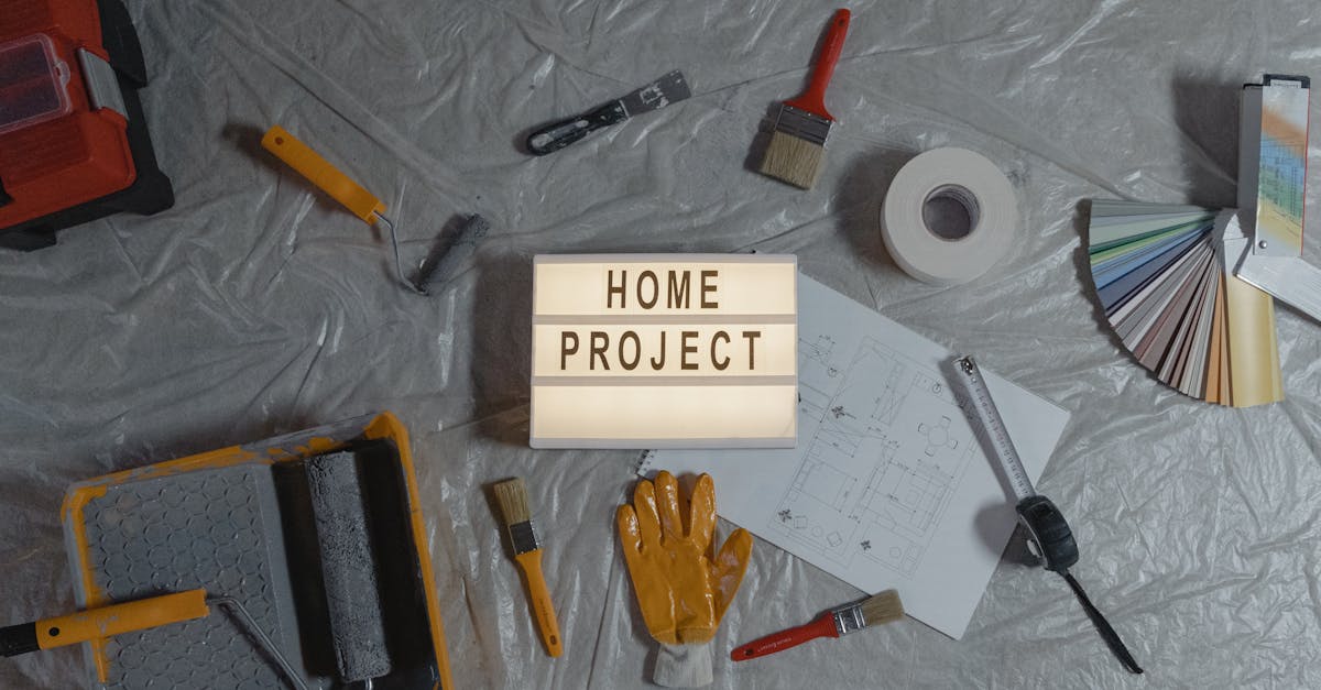 Flat lay of home improvement tools, paint samples, and blueprints for a DIY project.