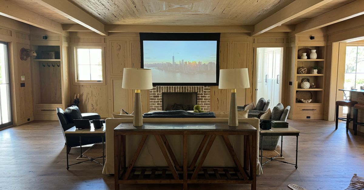Stylish living room with projector screen, cozy seating, and wooden décor.