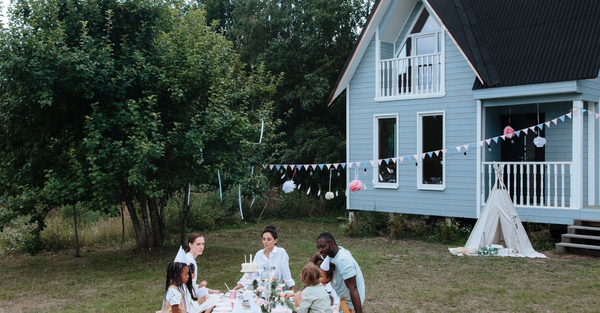 A diverse group enjoying a garden party around a table outdoors.